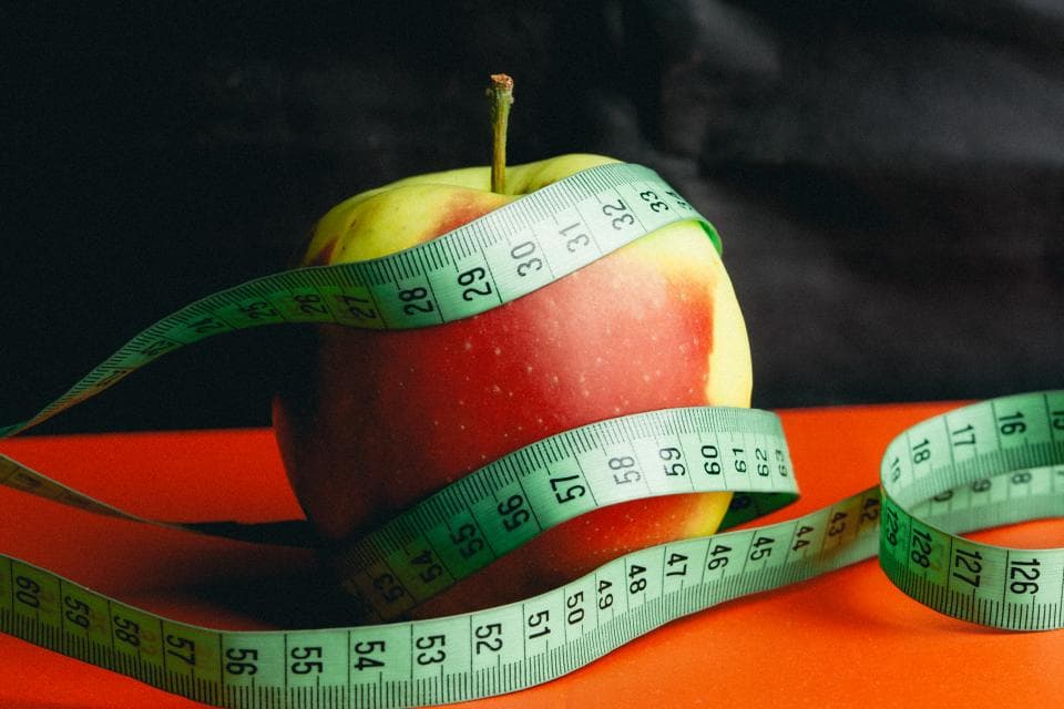 Manzana rodeada por una cinta métrica