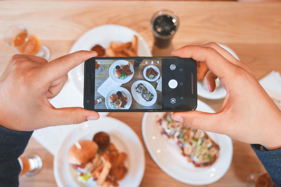 Persona fotografiando su comida con el teléfono