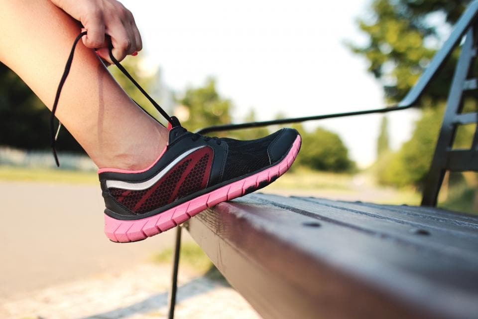 Runner tying her running shoes before a run